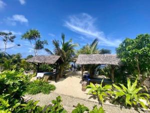 Eton的住宿－Banana Bay Beach Club，一个带两把遮阳伞和棕榈树的度假村