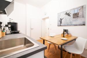 a kitchen with a sink and a wooden table at Ko-Living - Beatles und Banksy Suites & Studios am Eselsbrunnen - Altstadt - Küche in Halle an der Saale
