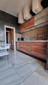 eine große Küche mit Holzschränken und Fliesenboden in der Unterkunft Central Apartment in Sofia