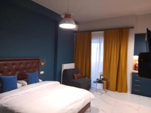 a bedroom with a bed and a chair and a television at Atlantis in Thessaloniki