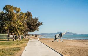 a dog walking along a sidewalk on the beach at 2 Bedroom Nice Apartment In Oropesa Del Mar in Oropesa del Mar