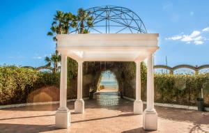 a white archway with a gate in front of the ocean at 2 Bedroom Nice Apartment In Oropesa Del Mar in Oropesa del Mar