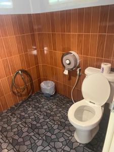 een badkamer met een toilet in een houten muur bij Pyramid Bangalow in Ban Laem Sai