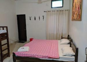 a bedroom with a bed with a pink blanket at Hotel Third Eye in Pushkar