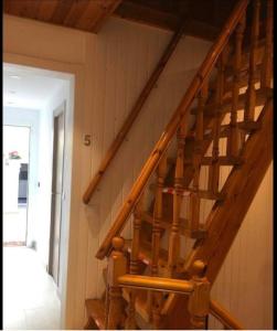 Una escalera de madera en una habitación con puerta en Casa Flores del Mediterráneo, en Badalona