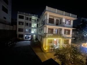 a tall white building at night with lights at Nirvaan Guest House (Hotel Bibidh) in Kathmandu