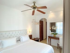 a bedroom with a white bed and a ceiling fan at Armata Boutique Hotel in Spetses