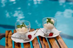 two glasses of ice cream and strawberries on a table at Eldorado Rustic Hotel in Nakuru