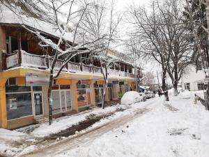 a snow covered street in a town with buildings at CITY HOUSE in Dulovo