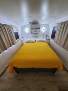 a large yellow bed in the back of a boat at Le Big Bus 