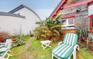 a yard with two chairs and a house at Holiday Home Agon Coutainville in Agon Coutainville +18 photos