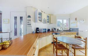 a kitchen with a wooden counter top and a table at Holiday Home Agon Coutainville in Agon Coutainville