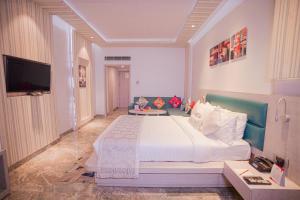 1 dormitorio con 1 cama grande y TV en Hotel Swarn Towers, en Bareilly
