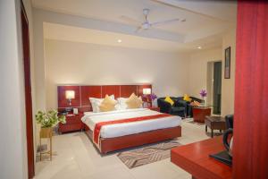 1 dormitorio con 1 cama y sala de estar en Hotel Swarn Towers, en Bareilly