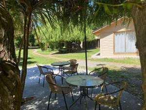 a group of tables and chairs under a tree at Cabañas Mi Quincho in Parral