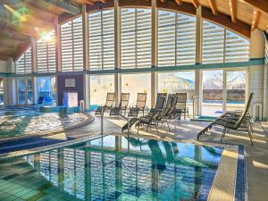 a swimming pool with chairs in a building at Harmónia Vendégház 100 méterre az Igali gyógyfürdőtől in Igal
