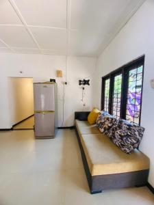 a living room with a couch and a refrigerator at Anosha Villa in Weligama