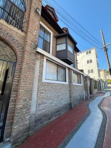 a brick building with a sidewalk next to a street at Casa Vivanco in Ensenada