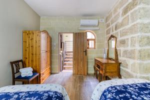 sypialnia z 2 łóżkami i drewnianym biurkiem w obiekcie Rb42 - Charming & Historic House w mieście Rabat