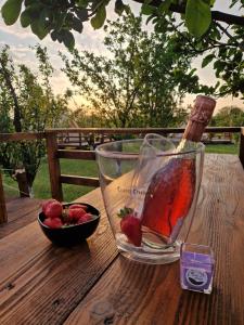 a glass bowl of strawberries on a wooden table at Glamping Livada cu lavanda 