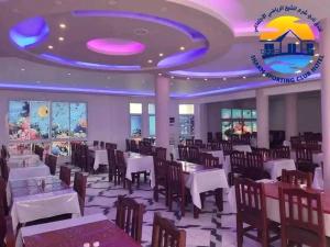 a restaurant with tables and chairs and a purple ceiling at Club Marine Residence in Sharm El Sheikh
