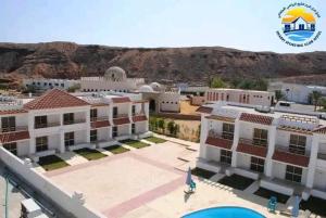 arial view of a building with a mountain in the background at Club Marine Residence in Sharm El Sheikh