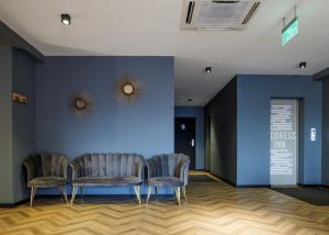 2 sillas y una mesa en una habitación con una pared azul en Address Inn en Tiflis