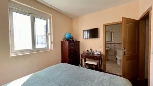 een slaapkamer met een bed, een raam en een badkamer bij Lisa sea view in Petrovac na Moru