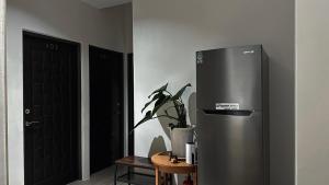um frigorífico de aço inoxidável num quarto com uma planta em 飛行船電梯民宿 em Taitung City