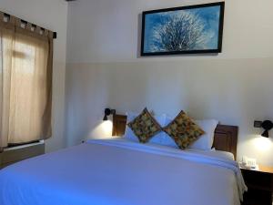 um quarto com uma grande cama branca e uma janela em AZURIA HOTEL em Lomé
