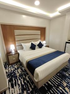 a bedroom with a large bed with blue and white pillows at دريم بارك العليا in Al Khobar