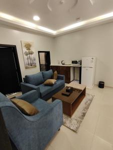 een woonkamer met twee blauwe banken en een salontafel bij دريم بارك العليا in Al Khobar