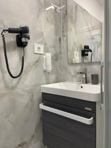 a bathroom with a sink and a phone next to a mirror at Style Central in Bucharest