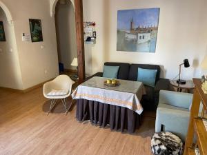 ein Wohnzimmer mit Tisch und Couch in der Unterkunft VIVIENDA SAN AGUSTÍN in Sevilla