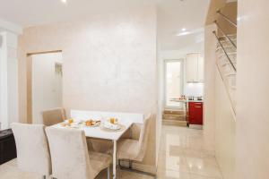 a white dining room with a white table and chairs at Apartman Mija in Split