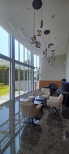 a living room with chairs and tables and windows at Apartemen Nuvasa Bay in Nongsa