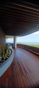 a wooden deck with a view of the ocean at Apartemen Nuvasa Bay in Nongsa