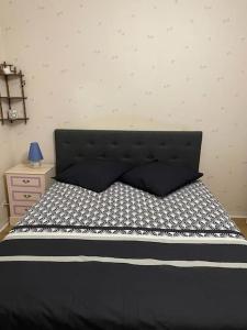 uma cama preta com uma cabeceira preta num quarto em Appartement spacieux Gentilly em Gentilly