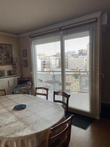 uma sala de jantar com uma mesa e uma grande janela em Appartement spacieux Gentilly em Gentilly
