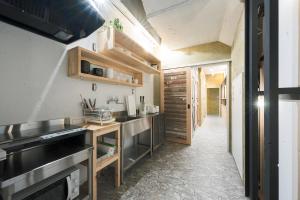 a kitchen with a sink and a stove at Kotori Coworking & Hostel Kotohira in Kotohira