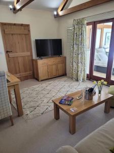 Телевизия и/или развлекателен център в Honeysuckle Cottage Annex with hot tub near Needham Market