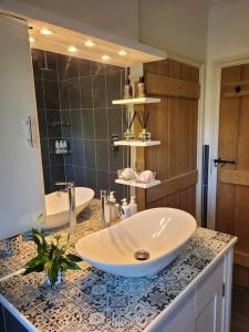 a bathroom with a sink and a mirror at Honeysuckle Cottage Annex with hot tub near Needham Market in Needham Market