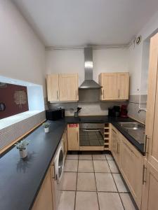a kitchen with wooden cabinets and a stove top oven at L'évasion arrageoise 58 m² in Arras +22 photos