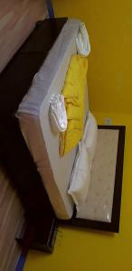 Bett mit gelber Decke und weißer Bettwäsche in der Unterkunft Moupiya Resort and Restaurant in Dāngchura