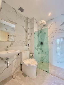 春蓬Calamint Residence Hotel ( คาลามิ้นท์)的配有马桶、水槽和淋浴的浴室