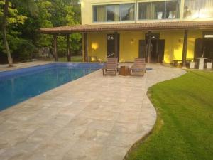 una casa con piscina y 2 sillas de césped en Olivia Bungalow, en Wattala