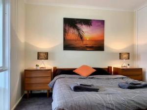 a bedroom with a bed with two night stands and two lamps at Quiet Holiday Home in Surf Beach VIC in Surf Beach