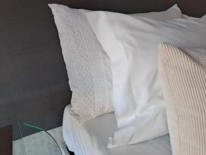 białą poduszkę siedzącą na łóżku w obiekcie SaberAmar City & Ria & More w mieście Aveiro