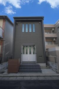 Una casa con una puerta blanca a un lado. en fuu, en Fukuoka