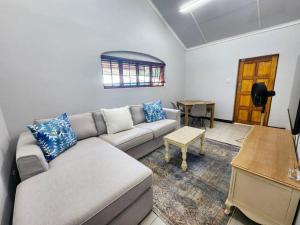 uma sala de estar com um sofá e uma mesa em Margate Manor em Pretoria
